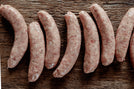 Raw sausages arranged on a wooden surface