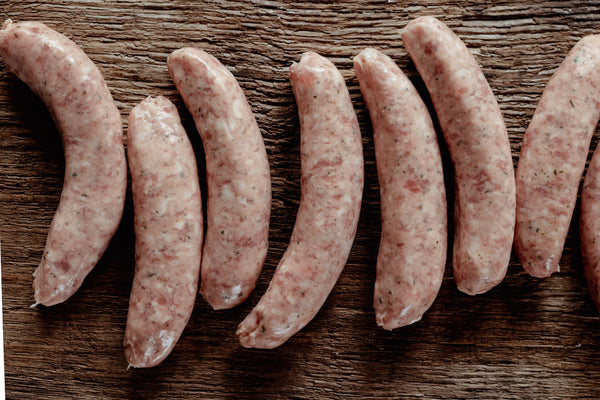 Raw sausages arranged on a wooden surface